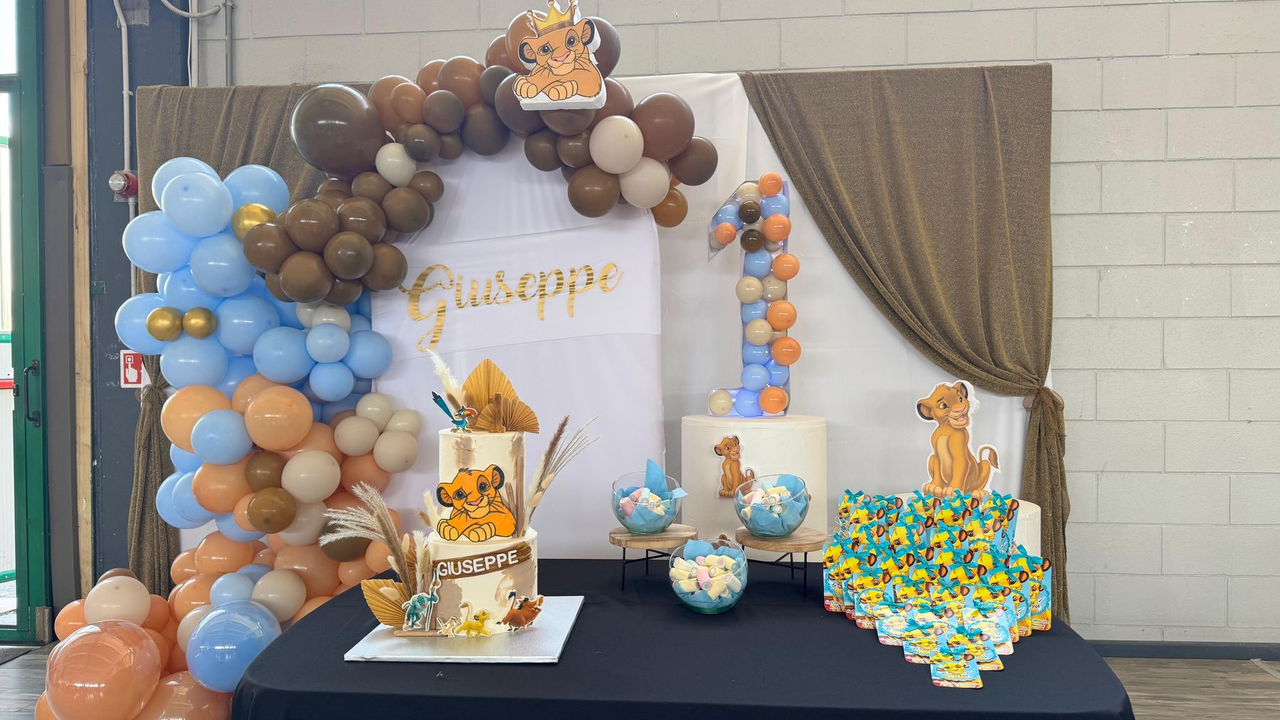 Allestimento a tema Re Leone con torta e arco di palloncini per un primo compleanno da Pito Pitù a Cabiate